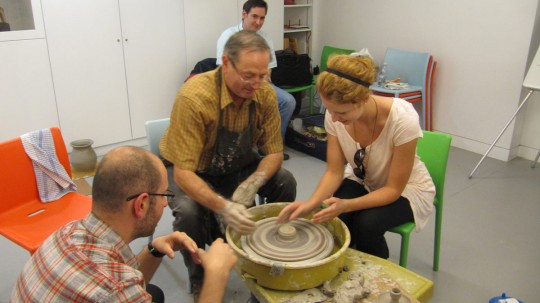 A member of the audience applying a hands-on approach to pottery