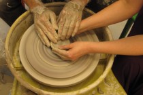 ... then guides the hands of the apprentice on the wheel